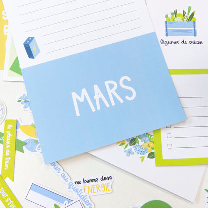 Cartes Project Life - Des fleurs et des saveurs, image montrant une pochette bleu clair avec "MARS" et des pages décoratives, fleurs et légumes illustrés.