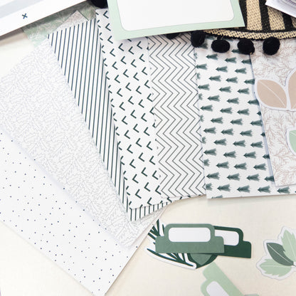 Paquets de papier décoratif à motifs modernes et géométriques verts et gris, avec étiquettes et pièces décoratives en dessous.